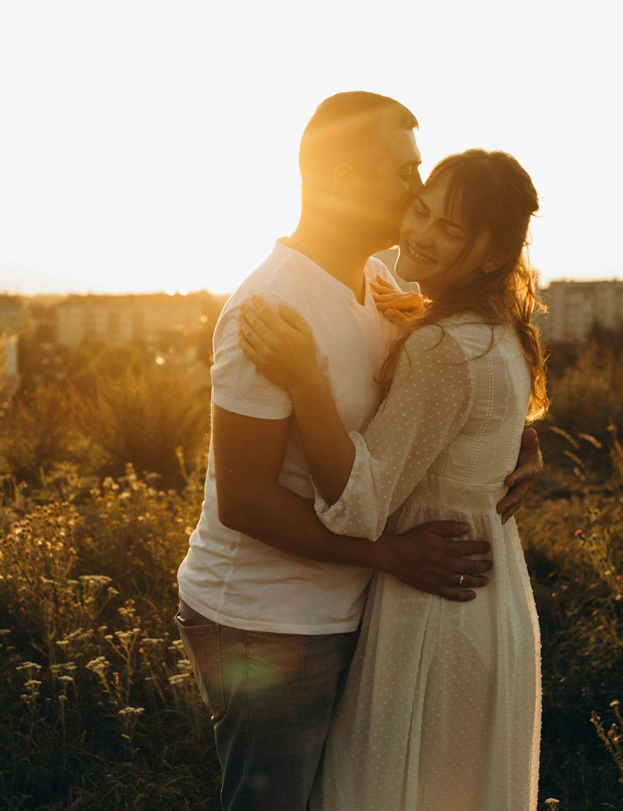 Dos personas se besan con cariño al atardecer